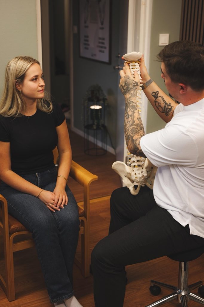 Robin går igenom ryggrad och bäcken med patient på kliniken.