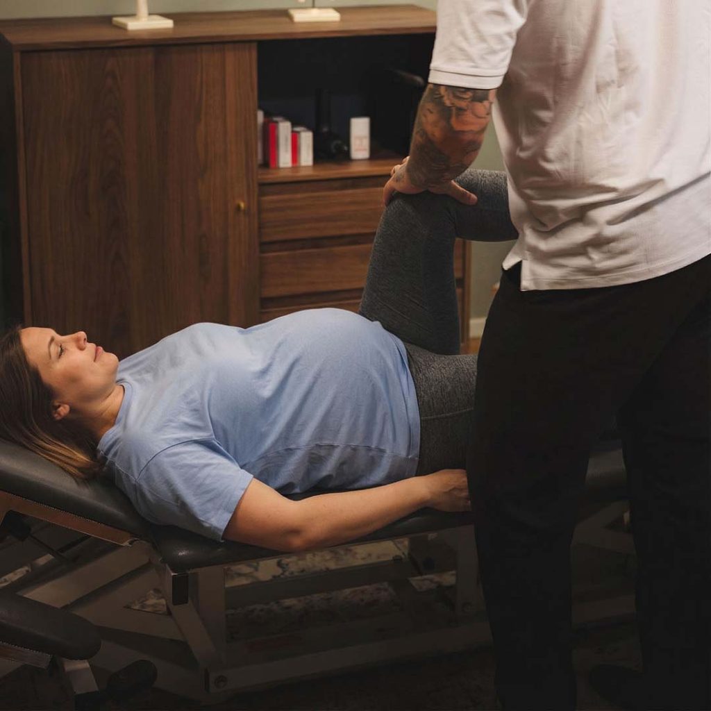 Robin behandlar gravid kvinna på behandlingsbänk på Norrtälje Rygg & Ledklinik.